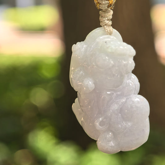 Natural Grade-A glutinous pale lavender Pixiu jadeite pendant hanging from its woven cord.