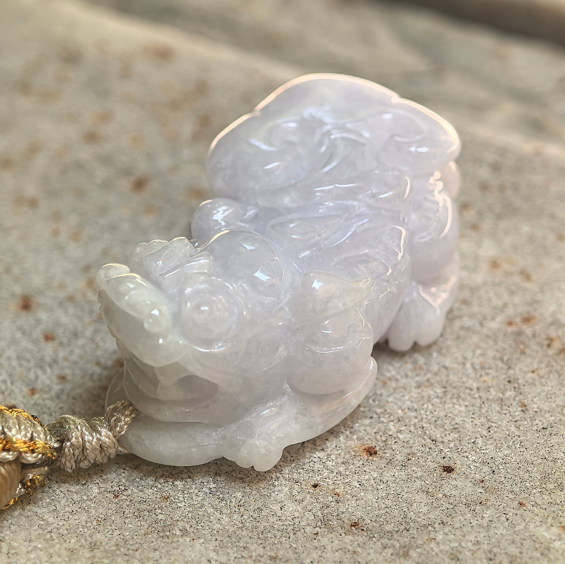 Close-up of the pale lavender jadeite Pixiu showing detailed facial features and polished craftsmanship.