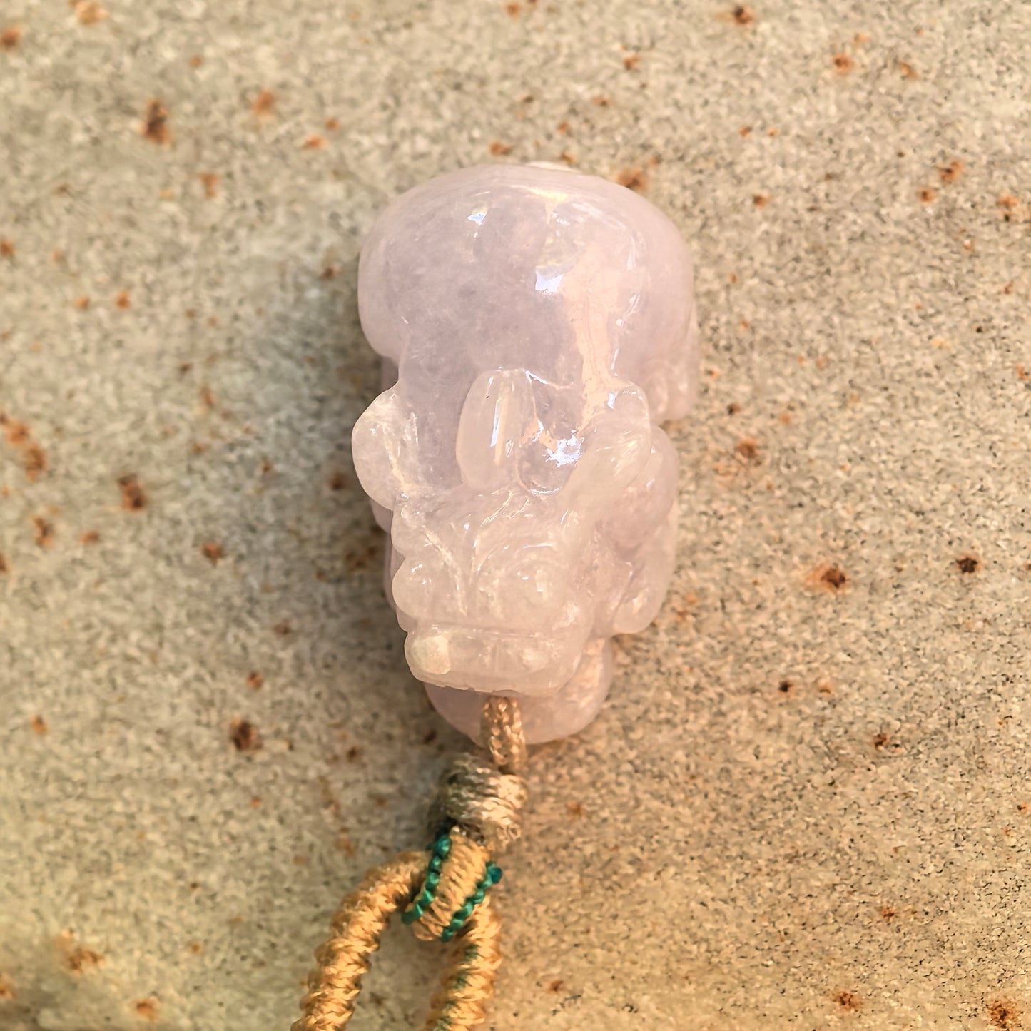 Top view of the pale lavender Pixiu jadeite pendant showing its rounded three-dimensional carving and natural jade texture.