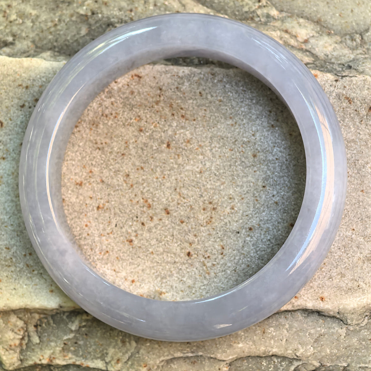 Top view of a glutinous lavender-blue jadeite D-shape bangle showing its continuous form, natural texture, and cool lavender tone.
