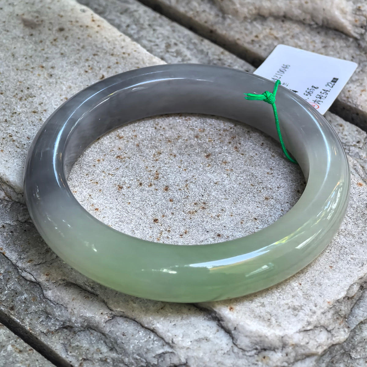 Natural two-tone Hetian jade bangle displaying the transition from smoky purple to celadon green.