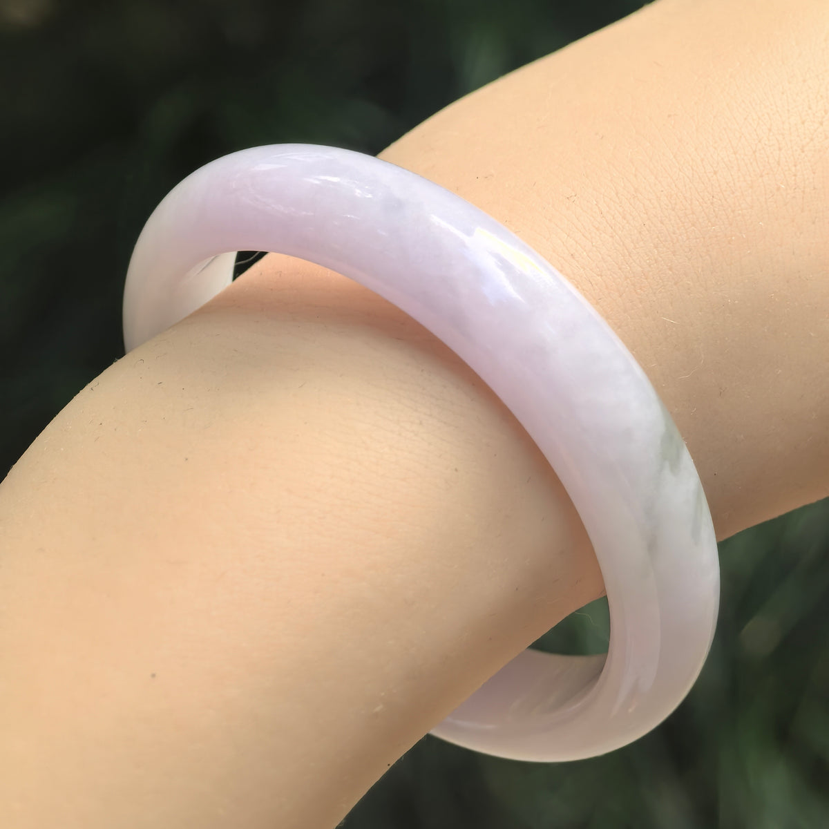 Natural Grade-A lavender jadeite bangle worn on the wrist, showing its rounded outer profile and soft glutinous texture.