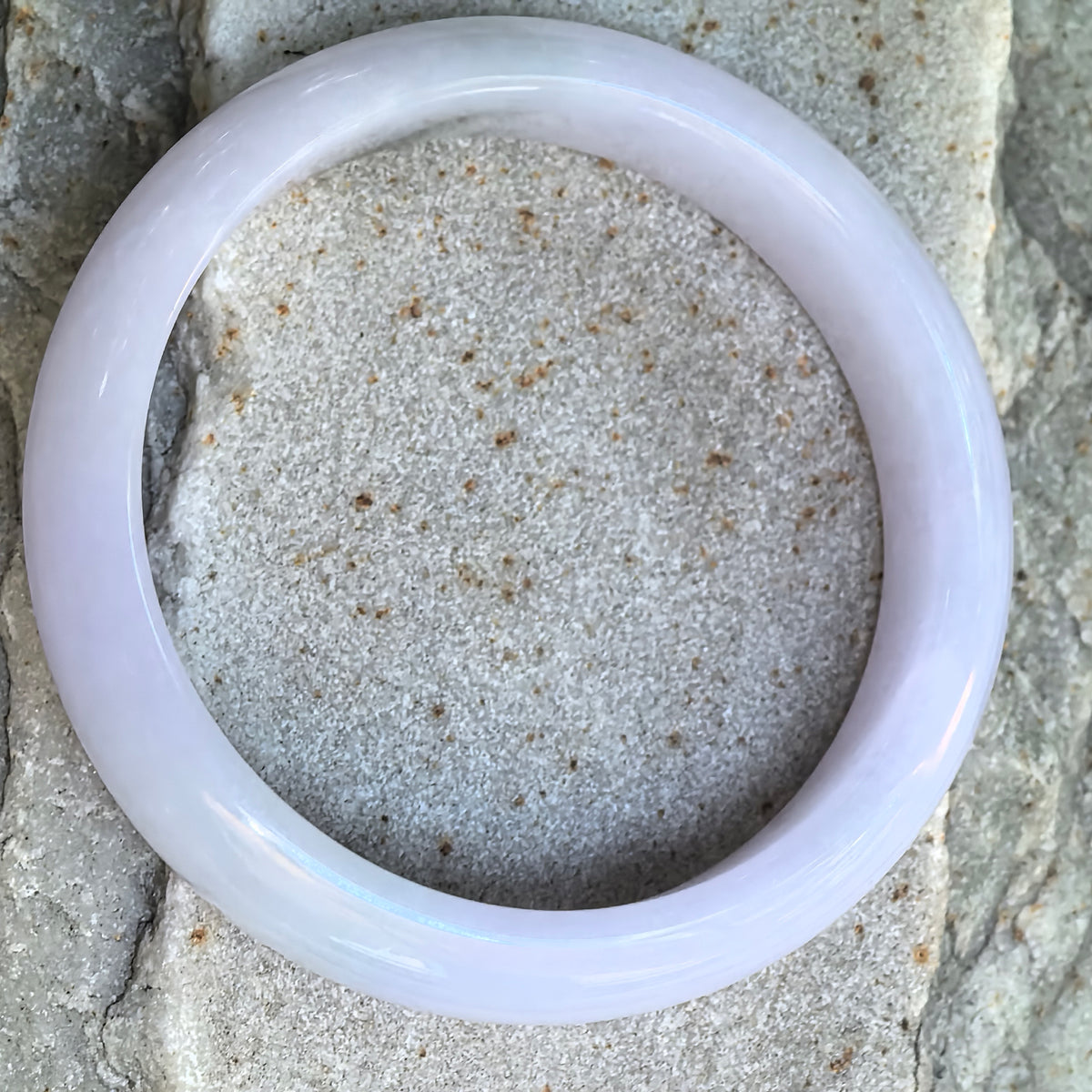 Top view of a glutinous lavender Burmese jadeite D-shape bangle showing its polished surface and natural color distribution.