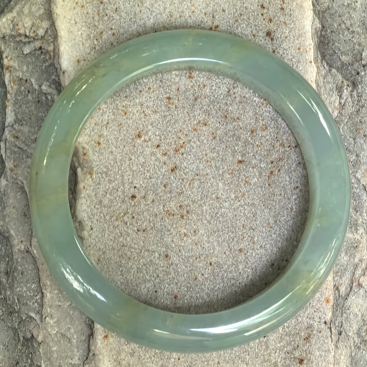 Top view of mint green Burmese jadeite D-shape bangle showing its smooth polish and clean circular profile.
