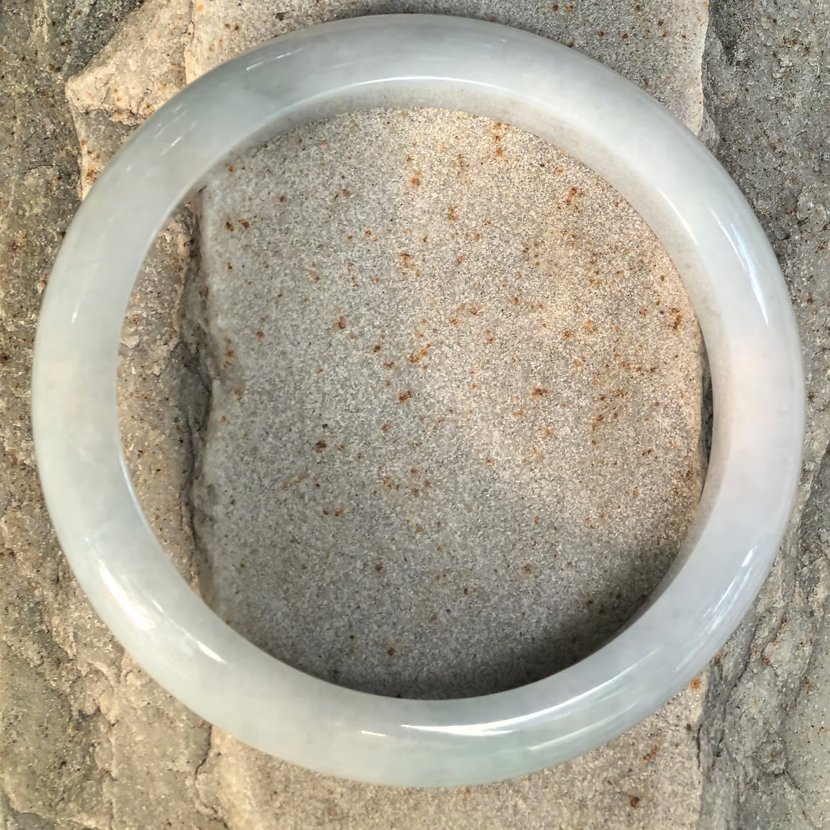 Top view of pale blue Burmese jadeite D-shape bangle showing its smooth polished surface and large inner diameter.