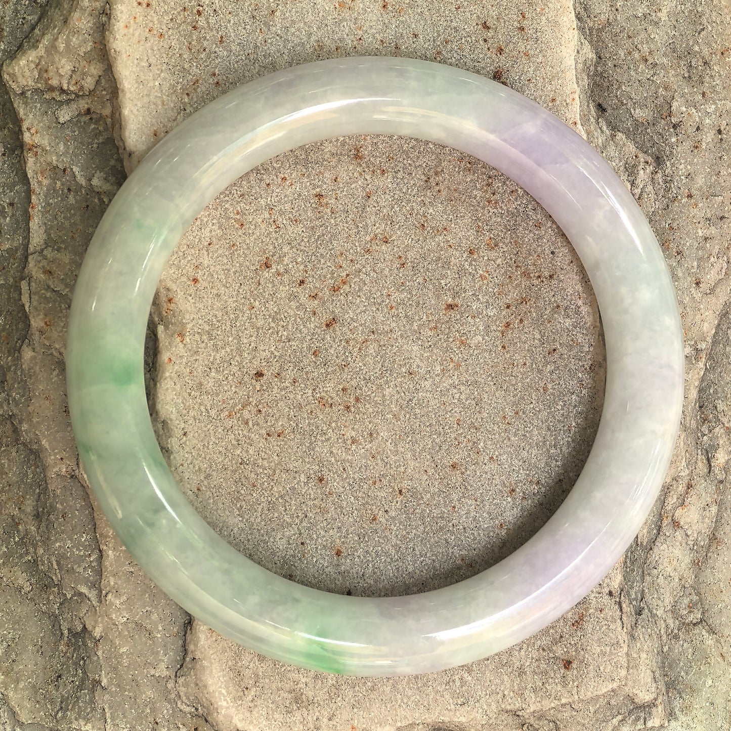 Top view of pale lavender and light green natural jadeite round bangle showing the full circular shape and natural color distribution.