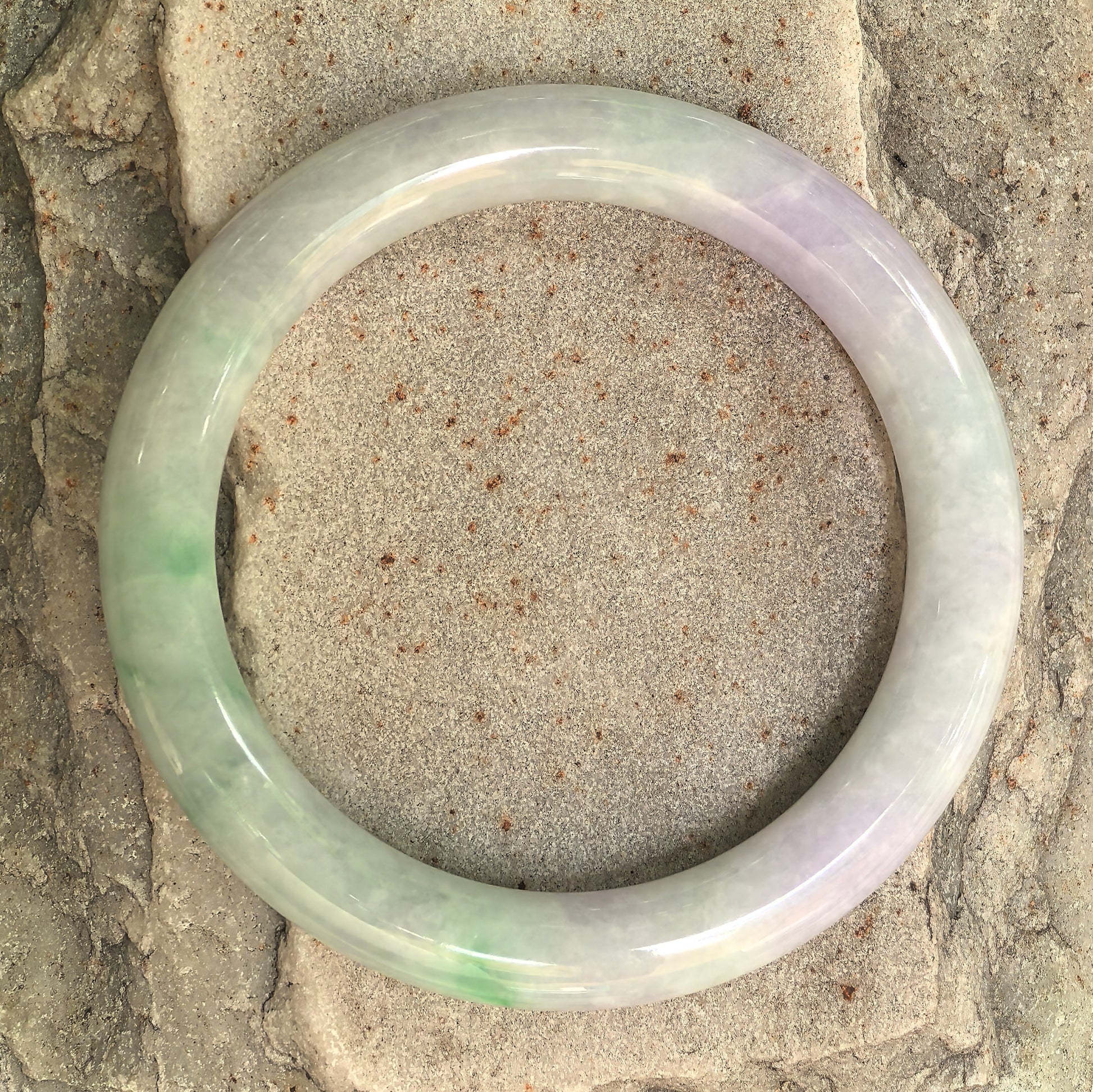 Top view of pale lavender and light green natural jadeite round bangle showing the full circular shape and natural color distribution.