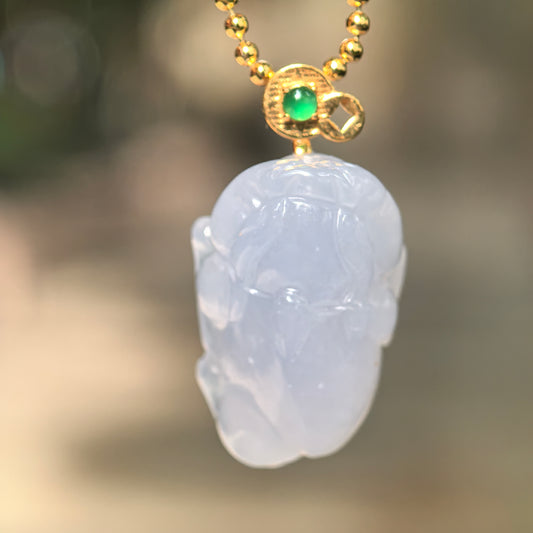 Natural Grade-A icy glutinous lavender Money Toad jadeite pendant hanging from a chain with an 18K gold bail and green accent stone.
