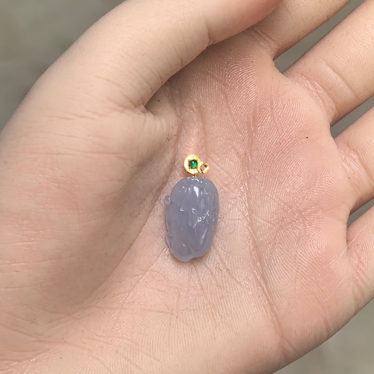 Natural Grade-A lavender Money Toad jadeite pendant shown in hand for scale with its three-dimensional carved form and 18K gold bail.