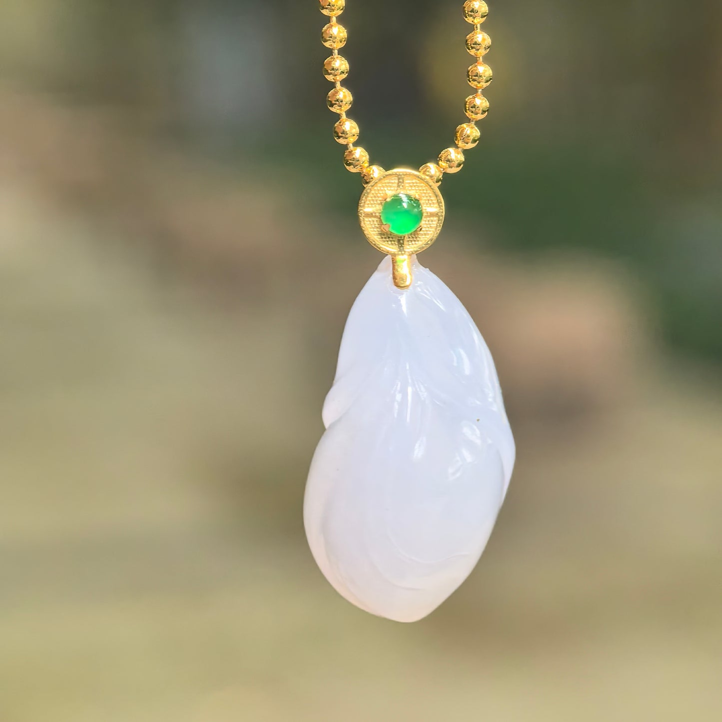 Natural Grade-A icy glutinous lavender magnolia jadeite pendant hanging from a chain, showing its compact floral shape and 18K gold setting.