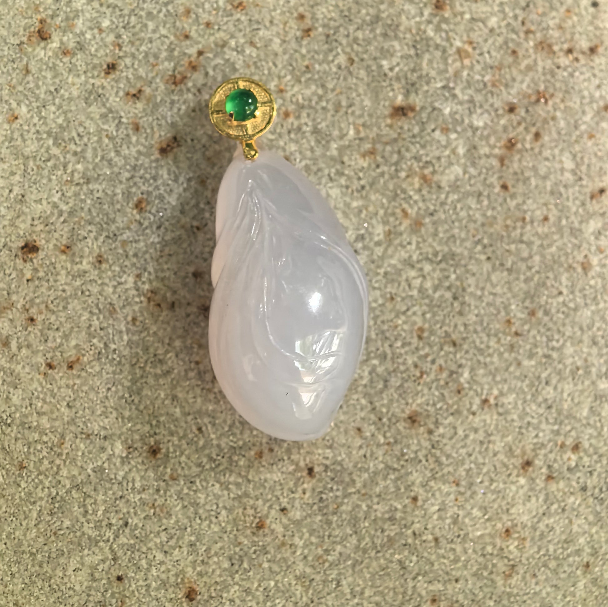 Front detail of icy glutinous lavender magnolia jadeite pendant showing smooth petal carving and soft natural luster.
