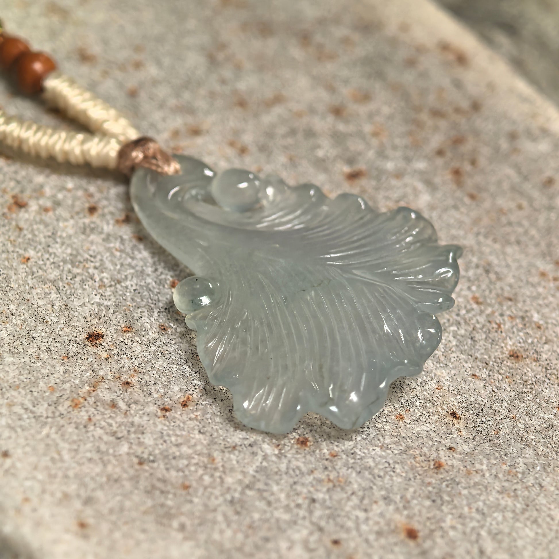 Close-up of Natural Grade-A light green jadeite ginkgo leaf pendant showing detailed radiating veins and icy texture.