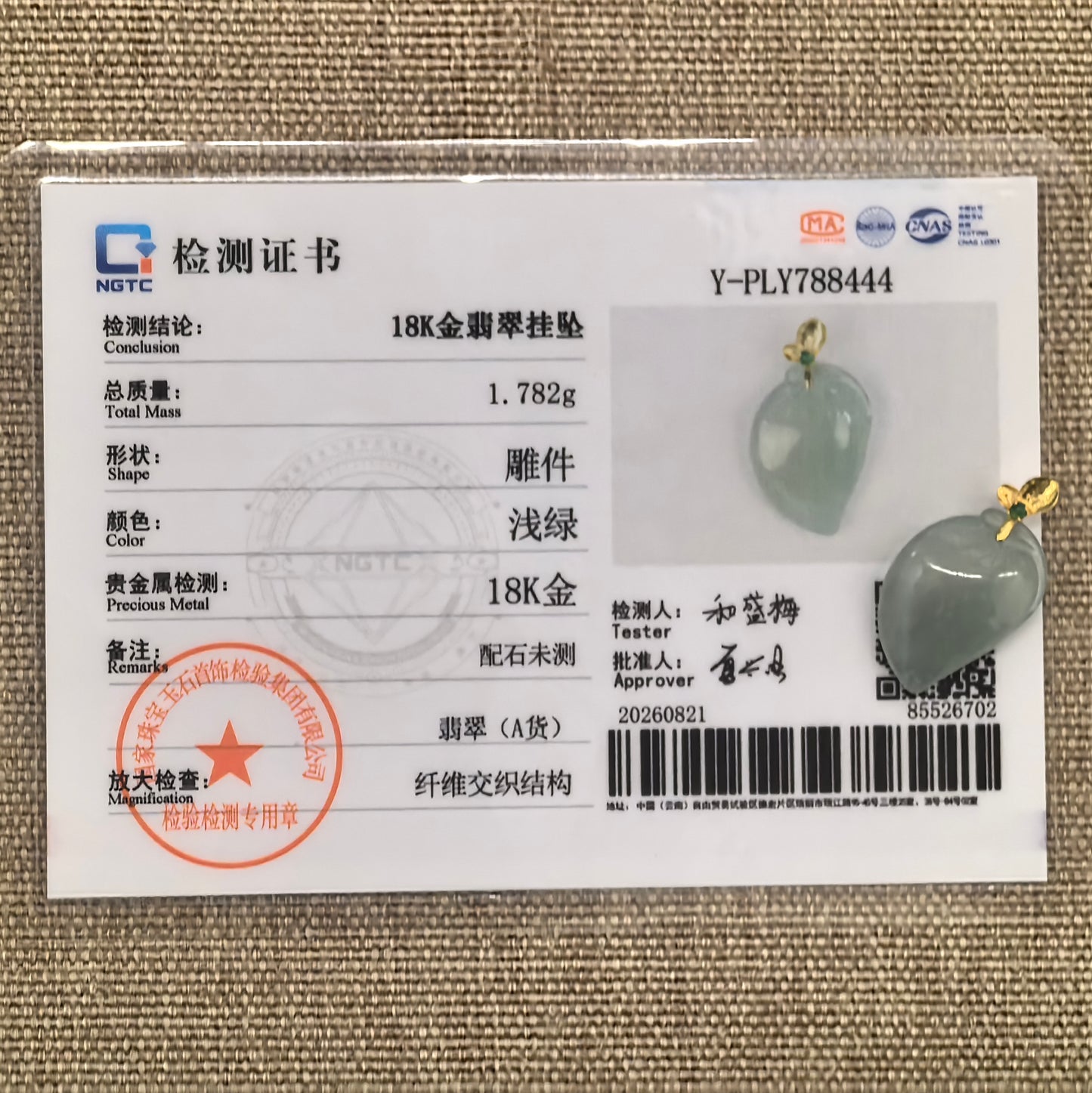 NGTC certified Natural Grade-A icy light green peach jadeite pendant with 18K gold bail shown with its matching certificate.