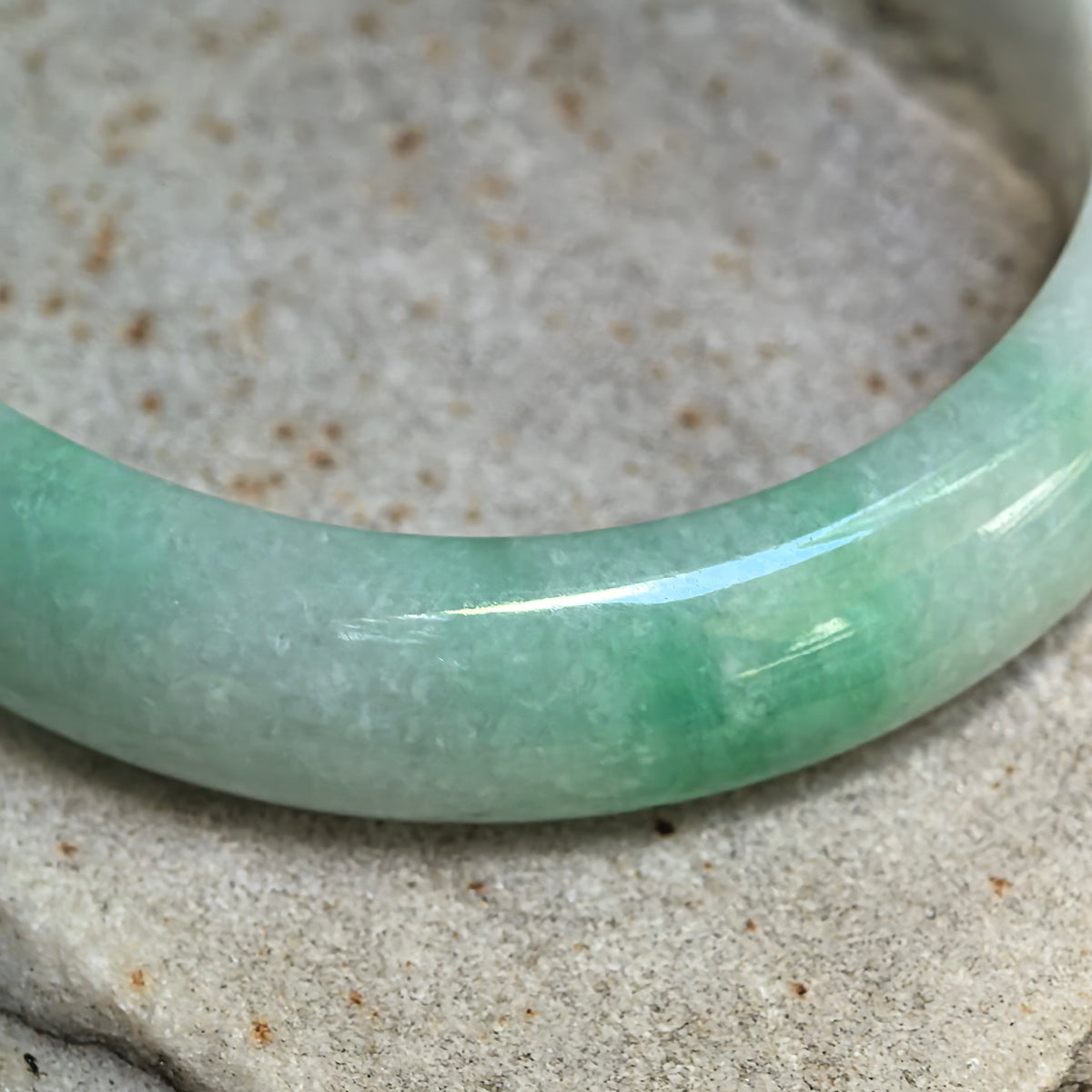 Glutinous White-Base Green Oval Jadeite Bangle – 53mm
