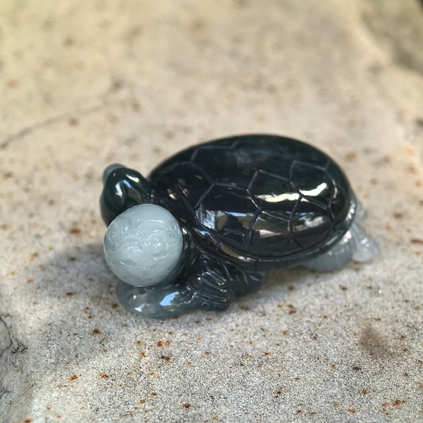 Side view of glutinous deep green jadeite turtle ornament showing the contrasting light green head and detailed shell structure.
