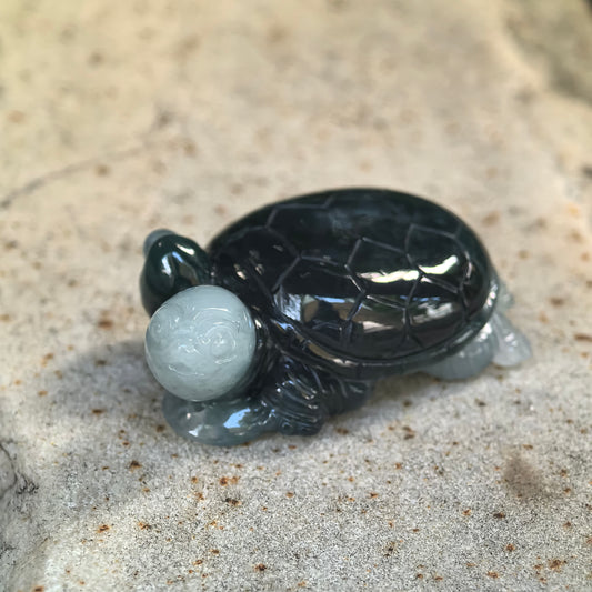 Side view of glutinous deep green jadeite turtle ornament showing the contrasting light green head and detailed shell structure.