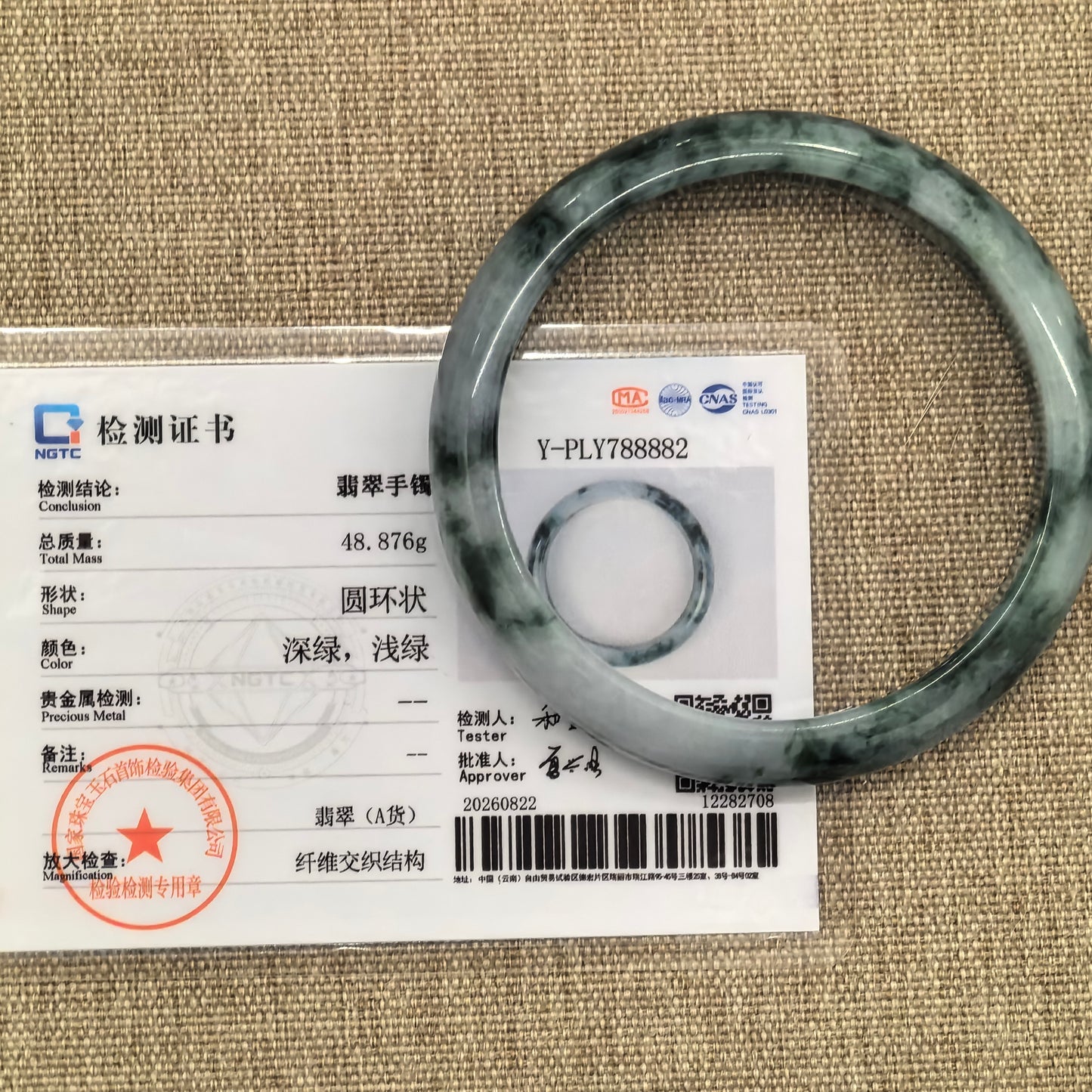 NGTC certified Natural Grade-A glutinous dark green floating flower jadeite D-shape bangle shown with its matching certificate.