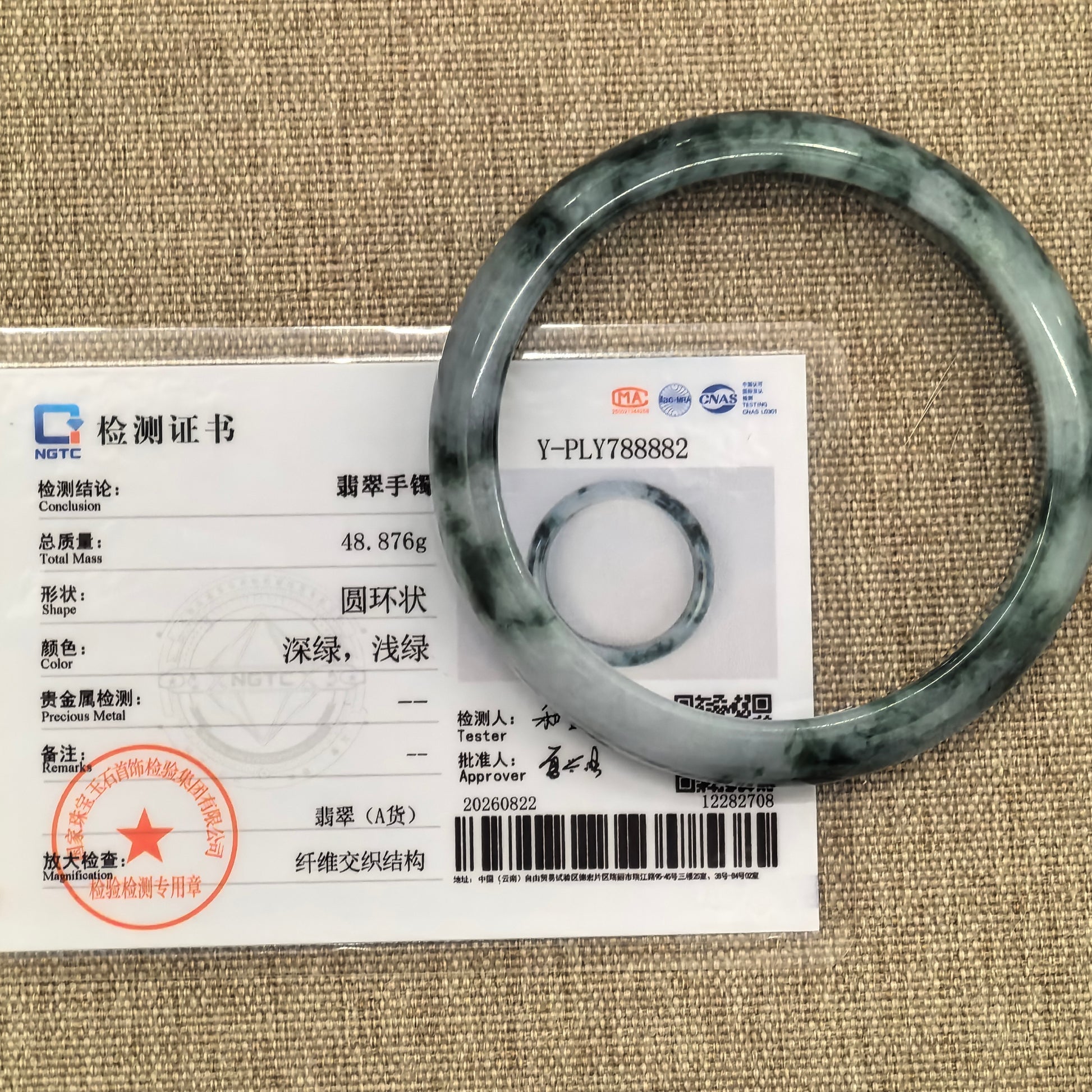 NGTC certified Natural Grade-A glutinous dark green floating flower jadeite D-shape bangle shown with its matching certificate.