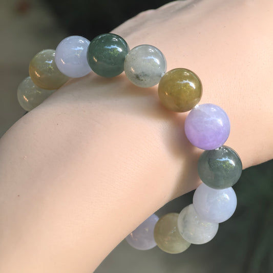 Close-up of a multicolor glutinous jadeite bracelet on the wrist, showing lavender, green, and yellow-brown beads with visible lines in some beads.