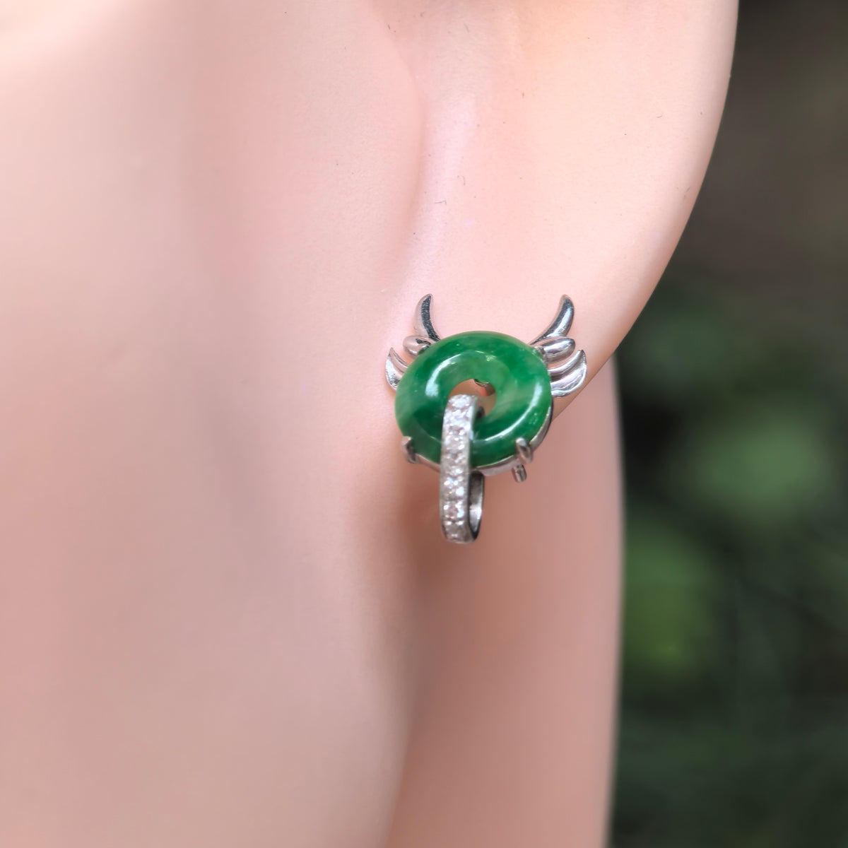 Image Alt Text
Green jadeite little devil stud earring worn on an earlobe, showing sculpted horns, wing-like details and a diamond-set loop.