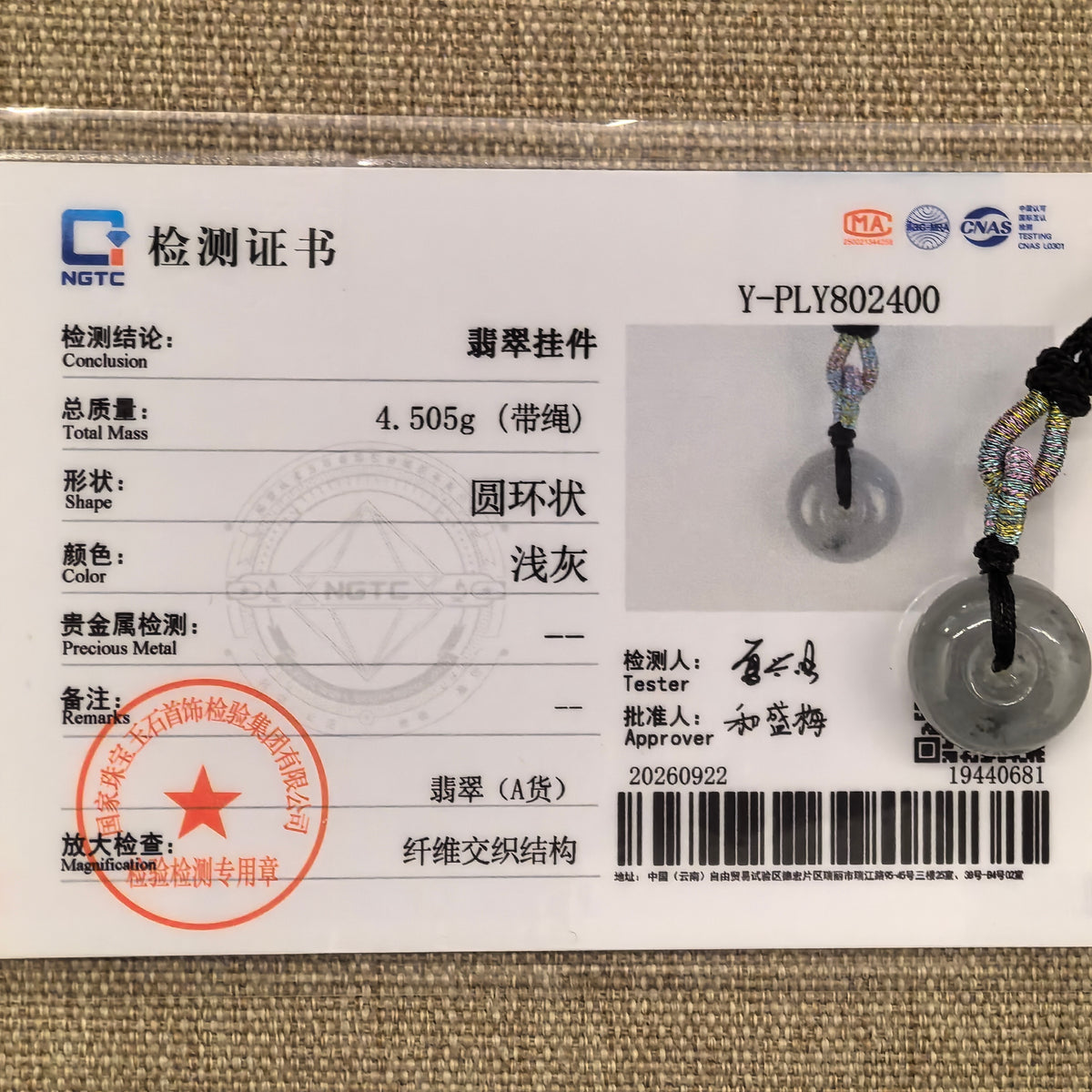Light gray jadeite Peace Pendant with its matching NGTC certificate, which records a weight of 4.505 g including cord.