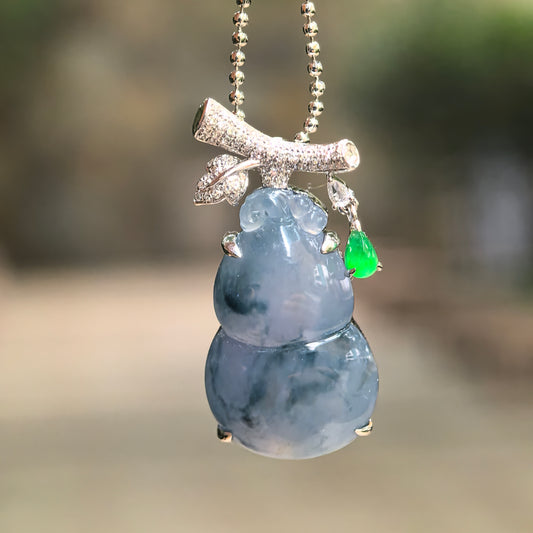 Icy blue-lavender jadeite gourd pendant hanging from a bead chain, showing its translucency, diamond accents and bright green teardrop detail.