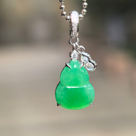 Icy vivid green jadeite Gourd Pendant hanging from a bead-style chain, showing its 18K gold setting, diamond-accented bail and small diamond-set Gourd charm.