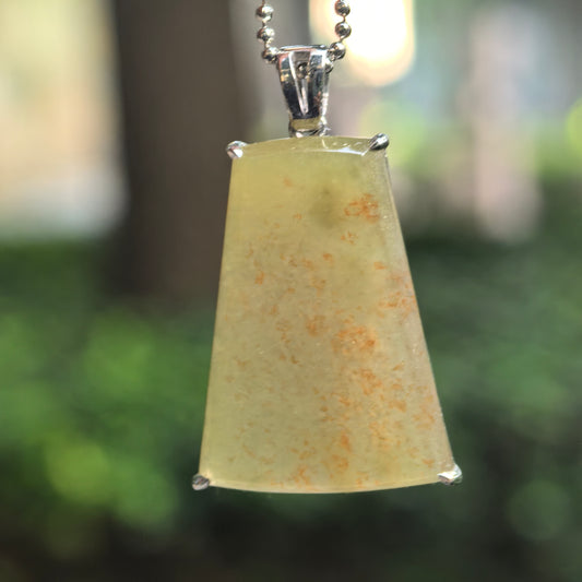 Icy glutinous yellow jadeite Plain Plaque Pendant with orange-brown flecks and a Pt950 platinum setting, hanging from a bead-style chain against a blurred background.