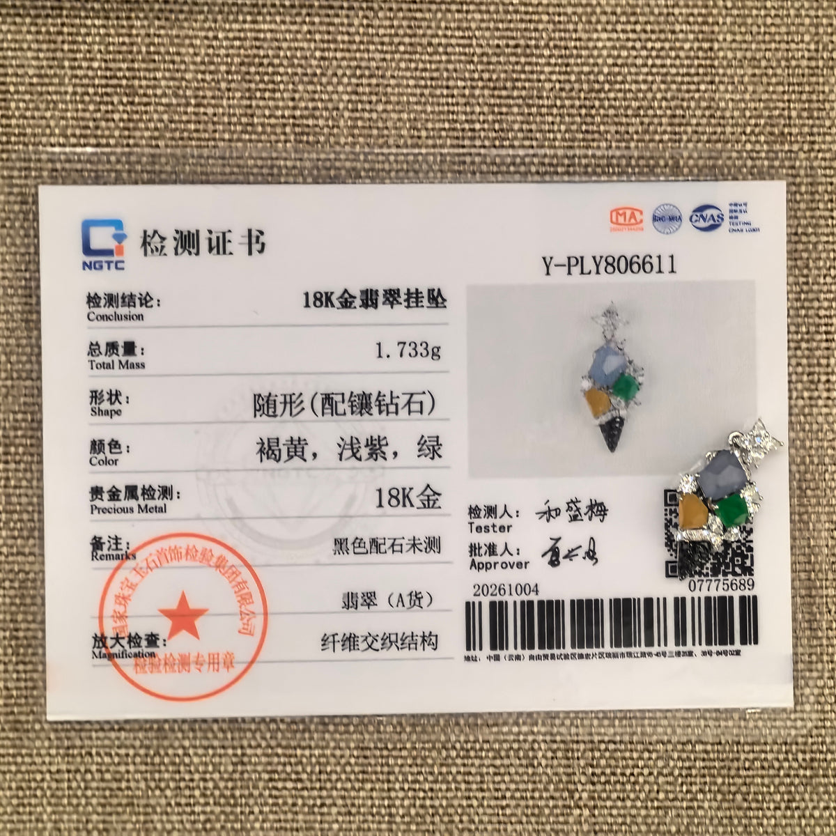 Multicolor jadeite ice cream cone pendant beside its matching NGTC certificate, number Y-PLY806611, on a woven background.