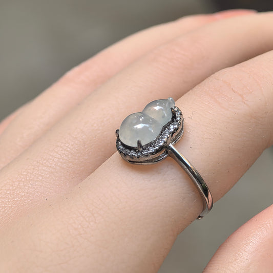 Angled view of the white jadeite gourd ring on a finger, highlighting the rounded carving, raised S925 silver setting and clear accent halo.