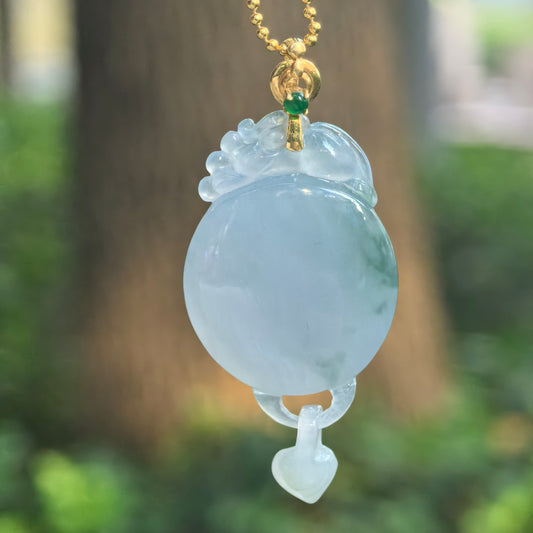 Purple jadeite Plain Plaque Pendant hanging from a chain, showing its round central face, carved upper crest, movable heart drop, and 18K gold bail.