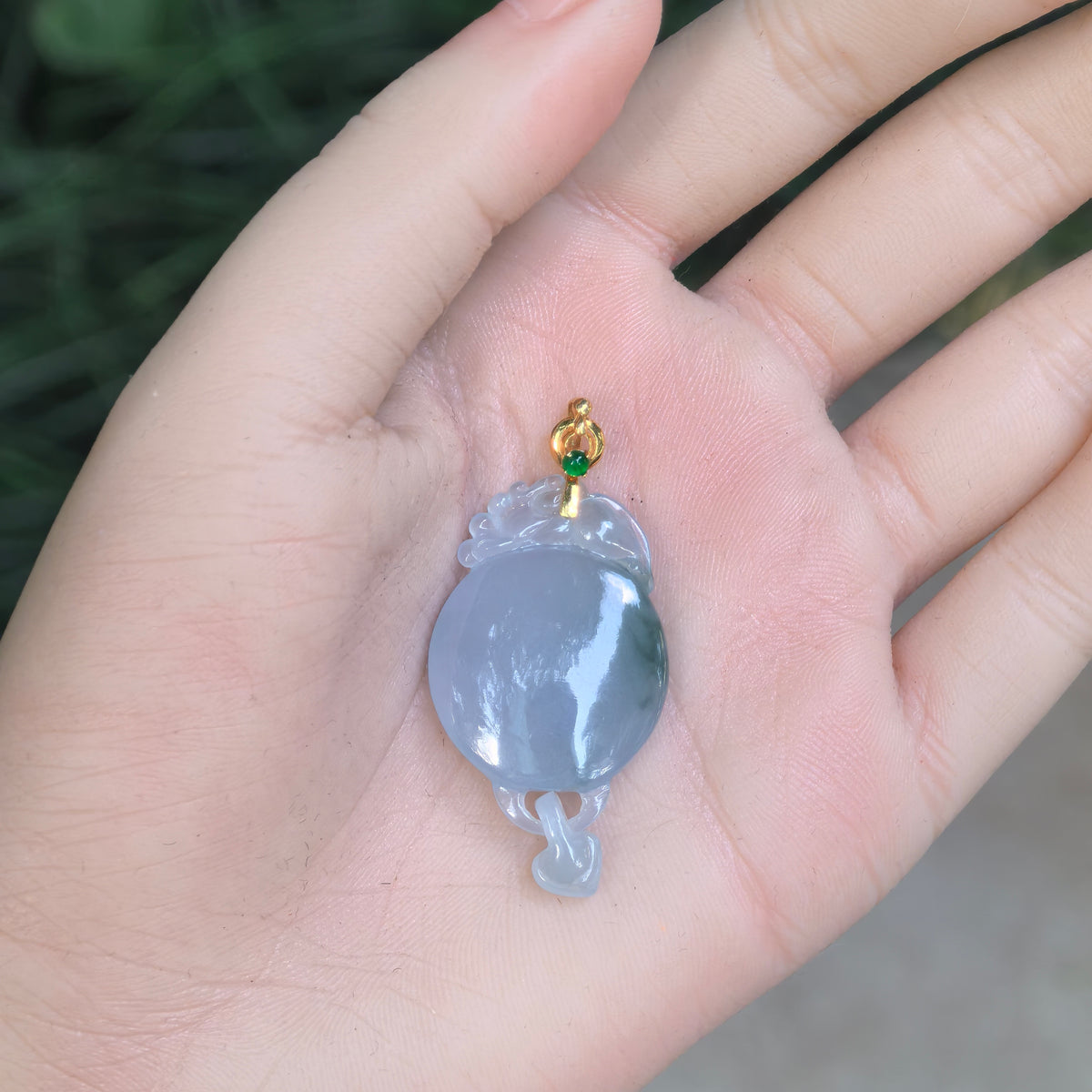 Purple jadeite Plain Plaque Pendant resting in an open palm, showing its overall proportions, localized green accents, and linked heart drop.