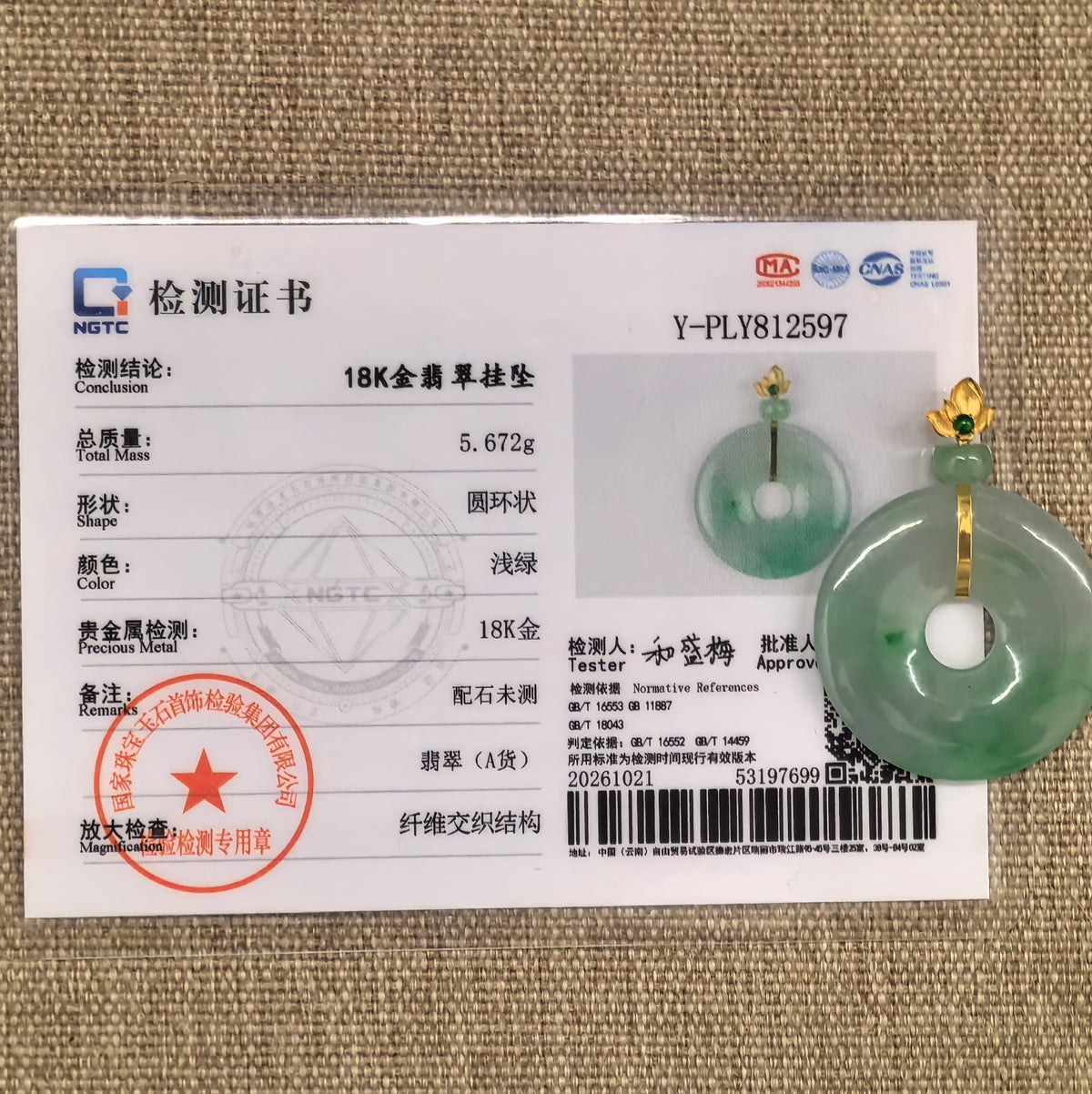 Light green jadeite Peace Pendant with an 18K gold floral bail beside its matching NGTC certificate.