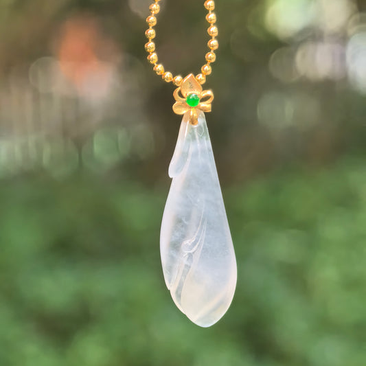 White jadeite Magnolia Pendant hanging from a chain, showing its translucency, natural internal texture and overlapping carved petals.