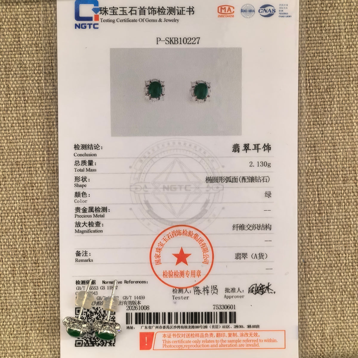 Pair of green jadeite and natural diamond stud earrings in 18K gold beside their matching NGTC certificate, with the posts and setting framework visible.